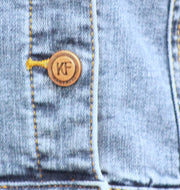 Button on blue denim jacket by KF Clothing
