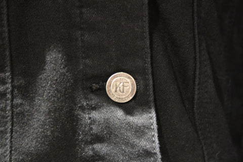 Close up of button on black denim jacket by KF Clothing